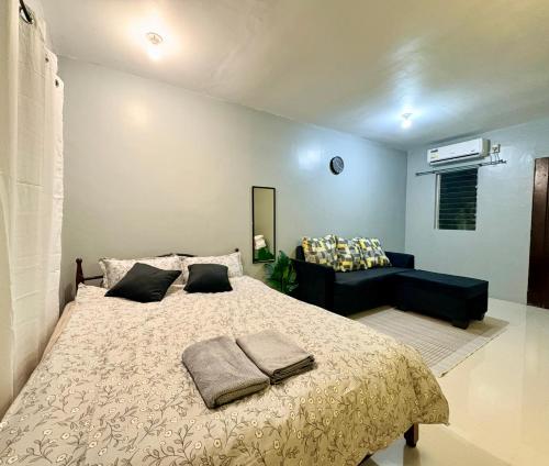 a bedroom with a large bed and a couch at ALCA Homestay in Palo
