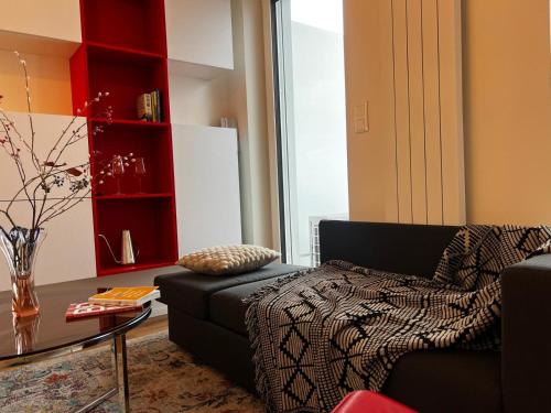 a living room with a black couch and a glass table at TUGENDHAT Boutique Suite in Komárov