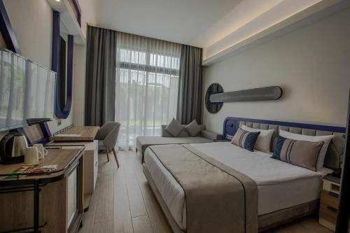 a hotel room with a large bed and a tv at Armella Hill Hotel in Side