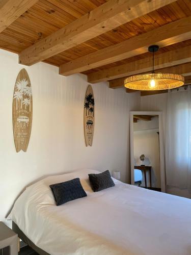 a bedroom with a large white bed with two pillows at Escapade Maritime in Dompierre-sur-Mer