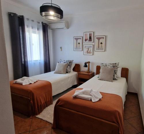 a bedroom with two beds with towels on them at Serenity Villa in Porches