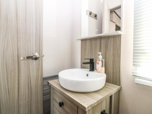a bathroom with a white sink on a wooden vanity at Plot 243 - Coldingham Bay Leisure Park in Eyemouth