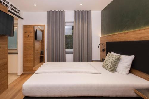 a bedroom with a large bed and a window at Hotel Restaurant Sennerbad in Ravensburg