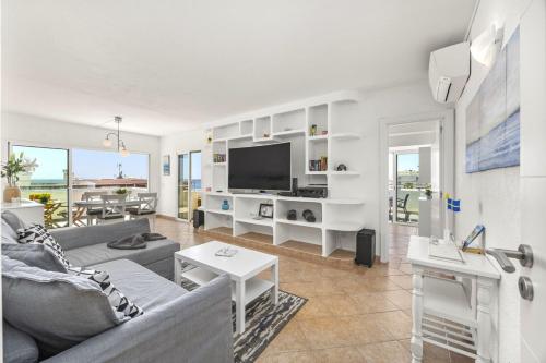 a living room with a couch and a tv at Algarve Sol Beach House in Quarteira