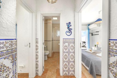 a bedroom with a bed and a bathroom with a toilet at Algarve Sol Beach House in Quarteira