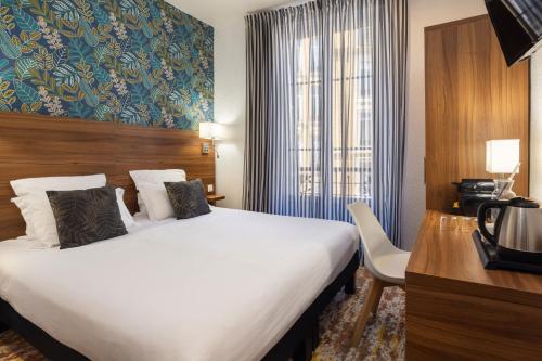 a hotel room with a large bed and a window at Hotel Khla Nice in Nice
