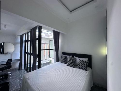 a bedroom with a bed and a large window at Villa Manis in Denpasar