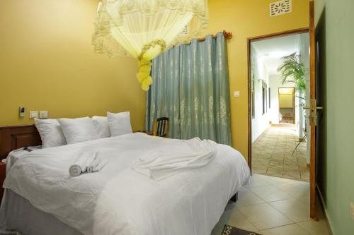 a bedroom with a white bed with a hand on it at Silent Patner Lodge in Arusha