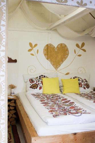 a bedroom with a bed with a heart on the wall at Folklórna chyža in Bojnice