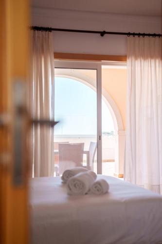 a bedroom with a bed and an open window at Vila da Praia 462-C01 in Óbidos