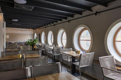 a row of tables and chairs in a restaurant with windows at Botel Marina in Prague