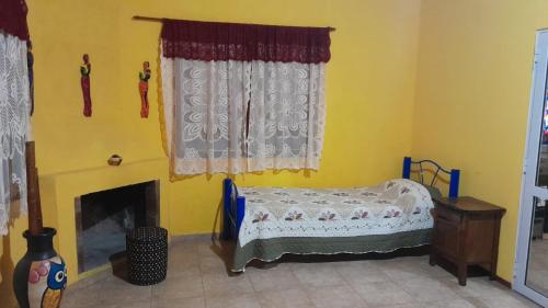 a bedroom with a bed and a fireplace and curtains at Cuesta Blanca cabañas in Cuesta Blanca
