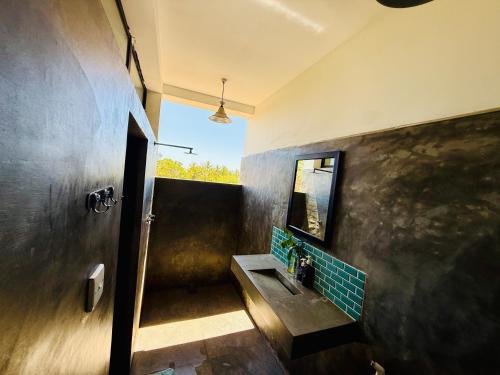 a bathroom with a sink and a mirror at REZ SPACE Apartment 01 in Hiriketiya