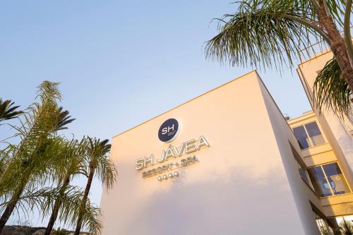 a sign on the side of a building with palm trees at SH Jávea in Jávea