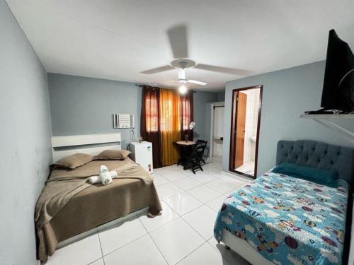 a bedroom with a bed and a table in a room at Suítes em Bacaxá Saquarema in Saquarema