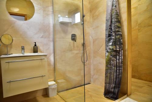 a shower with a glass door in a bathroom at Gyömbér Tanya in Ásotthalom