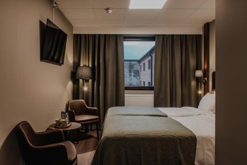 a hotel room with a bed and a window at Home Hotel Bristol in Arvika