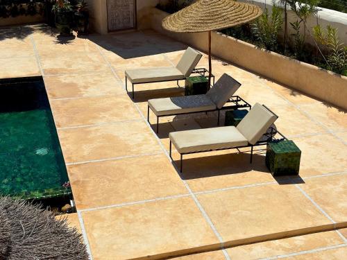 a patio with two lounge chairs and a pool at Palais Zoa in Essaouira