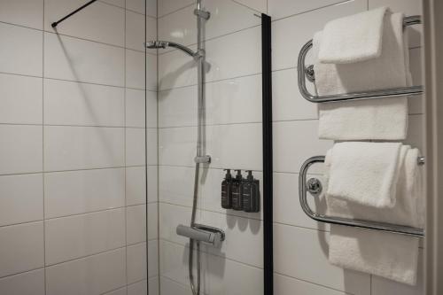 a shower with white towels in a bathroom at Home Hotel Bristol in Arvika