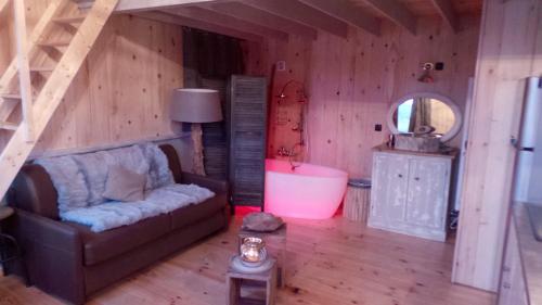 a living room with a couch and a mirror at Cabanes flottantes et gîtes au fil de l'eau in Colleville