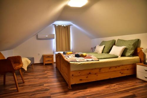 a bedroom with a bed with a wooden floor at Gyömbér Tanya in Ásotthalom