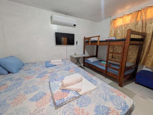 a bedroom with a bed and a bunk bed at Rubilla's Homestay and Motor Rental in Mambajao