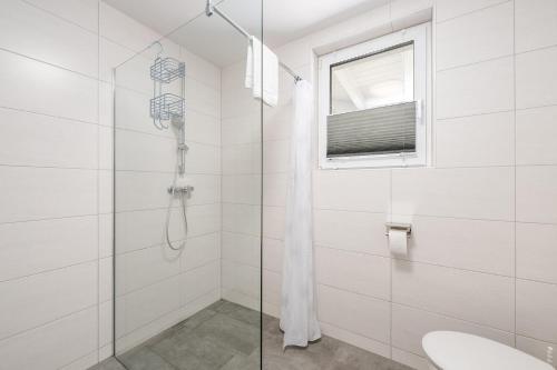 a white bathroom with a shower and a sink at Appartement Franz Josef - by myNests in Aich