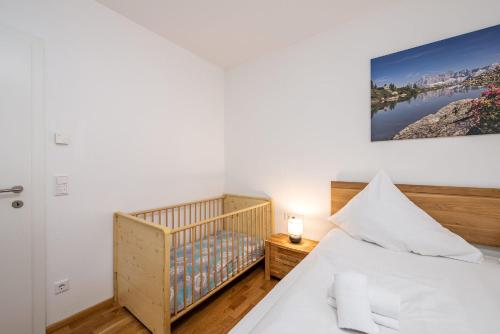a small bedroom with a crib and a bed at Appartement Franz Josef - by myNests in Aich