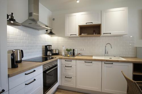 a kitchen with white cabinets and a sink at Ferienwohnung Zweites Zuhause in Büsum