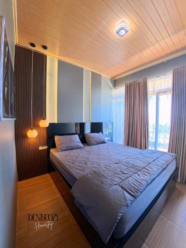 a bedroom with a large bed with a wooden ceiling at Denis cozy homestay in Senaru