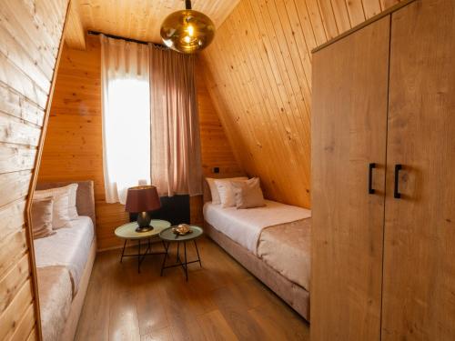 a bedroom with two beds in a wooden cabin at Reserve Resort Lagodekhi in Lagodekhi