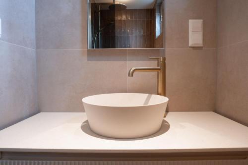 a bathroom with a white sink and a faucet at Luxe appartement in het hart van Castricum in Castricum