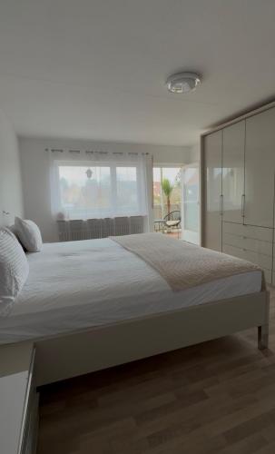 a bedroom with a large bed and a large window at Sternlicht Rachida in Albstadt