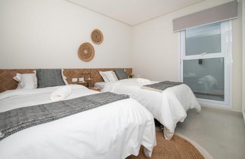 a bedroom with two beds and a window at Stylish 2BR Apt in Top Location in Asunción