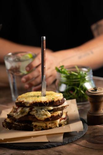 a sandwich with a knife sticking out of it on a table at Campanile Maubeuge in Maubeuge