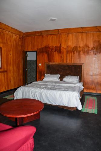 a bedroom with a large bed and a table at Shiny cot resort in Nuwara Eliya