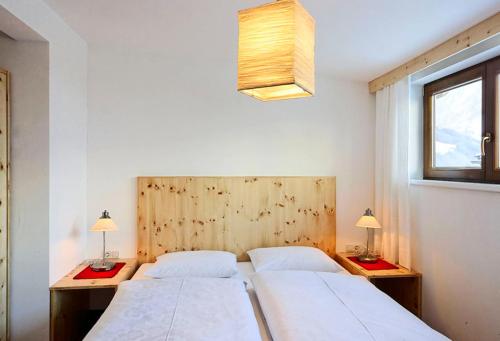 sypialnia z 2 łóżkami i 2 stołami z lampkami w obiekcie Apartments Nindl w mieście Neukirchen am Großvenediger