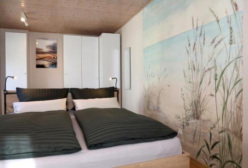 a bedroom with a bed and a painting on the wall at Häuschen im Grünen in Bansin