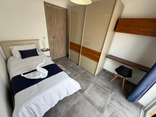 a bedroom with a bed with a swan on it at Serenità - Seaview Penthouse in Marsaskala