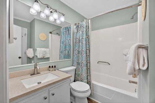 a bathroom with a sink and a toilet and a mirror at SC309A: 309A Sea Cabin in Isle of Palms
