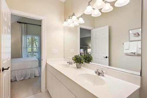 a white bathroom with a sink and a mirror at SM14: 14 Silver Moss in Kiawah Island