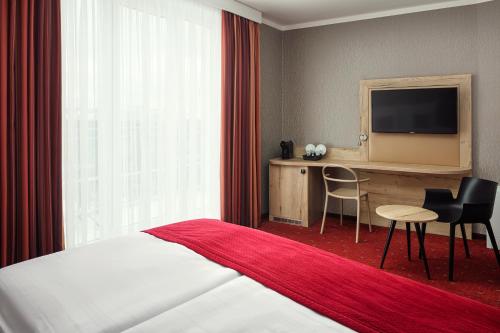 a hotel room with a bed and a desk and a television at Astoria Hotel in Prague
