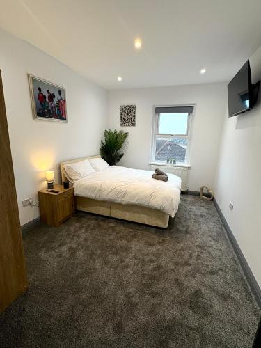 a bedroom with a large bed and a window at Spacious 4 Bed Retreat, 2 Bath, Sleeps 8 plus 2, Beach, Bars, Dinning, Shops, Golf, for Groups, Contractors or Families in Bournemouth
