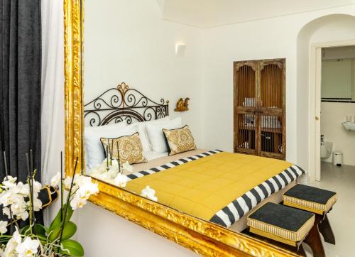 a bedroom with a bed with a large mirror at Villa Pietra Santa in Positano