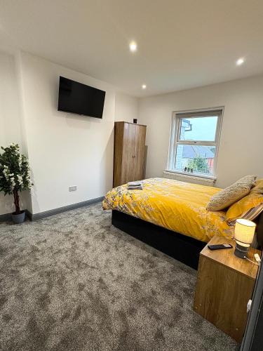 a bedroom with a large bed and a television at Spacious 4 Bed Retreat, 2 Bath, Sleeps 8 plus 2, Beach, Bars, Dinning, Shops, Golf, for Groups, Contractors or Families in Bournemouth