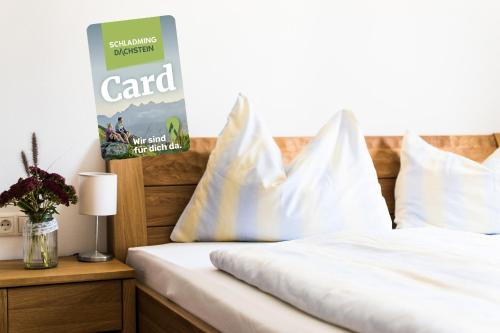 a bed with white pillows on top of it at Gästehaus Erika - by myNests in Schladming