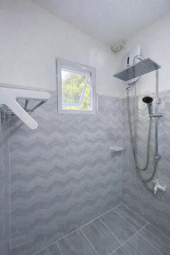 a bathroom with a shower and a window at Heidi's Guesthouse in Siquijor