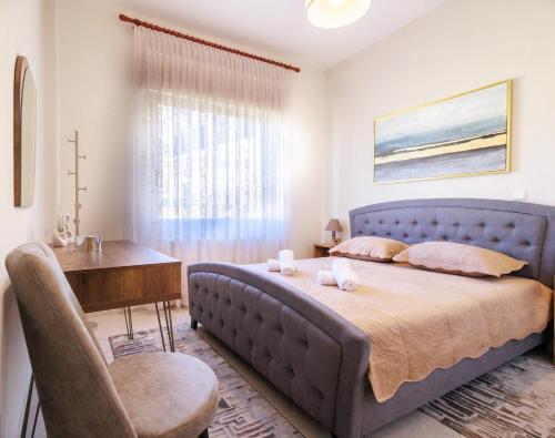 a bedroom with a blue bed with a desk and a table at Philoxenia House in Sidirokastro