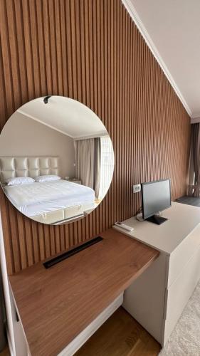 a bedroom with a bed and a desk with a computer at Perla Petrus in Rafailovici