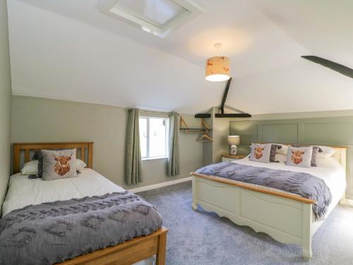 a bedroom with two beds and a window at 3 Woods Farm House in Chippenham